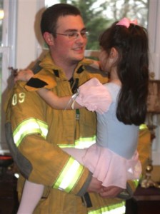 Firefighter brother holds little ballerina sister