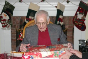 Elderly man opening Christmas package