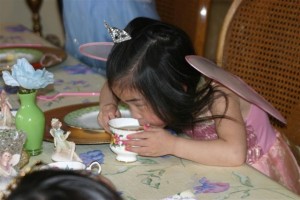 3 year old drinking from tea cup