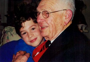 Little boy snuggling elderly man