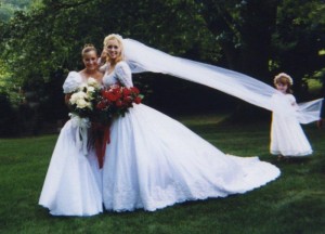 Viel blowing in wind, bride and maid of honor, child watches bride