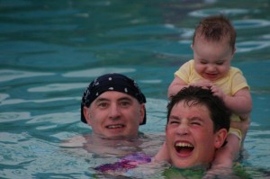 Caribbean baby pulling hair baby pulling brother's hair bandana on head happy family