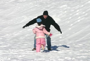 Dad greets daughter with outstretched arms daughter runs into dad's arms outstretched arms snow hug snow _