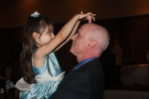Dad holds up daughter daughter in blue dress proud dad dad and daughter being silly