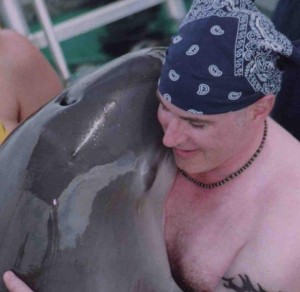 Hugging a dolphin dolphin hugs Phillip hugging a dolphin Phillip Let's Talk radio host bandana warm emb_
