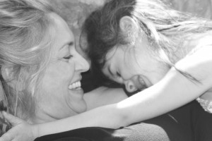 Mom and daughter giggling and snuggling, love and warmth, tenderness, snuggling on couch