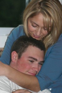 Mom snuggling son, nurturing, protecting, tenderness, comfort
